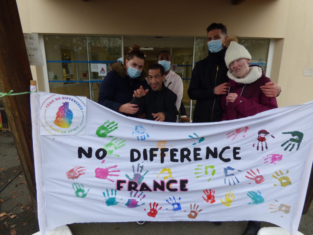 Un groupe de résidents prend la pose devant la MAS et une grande banderole au nom de la course