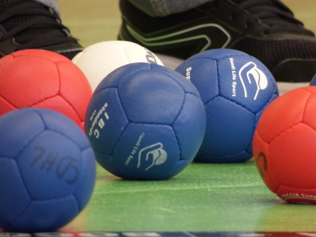 Boules de Boccia bleues, blanches et rouges au sol